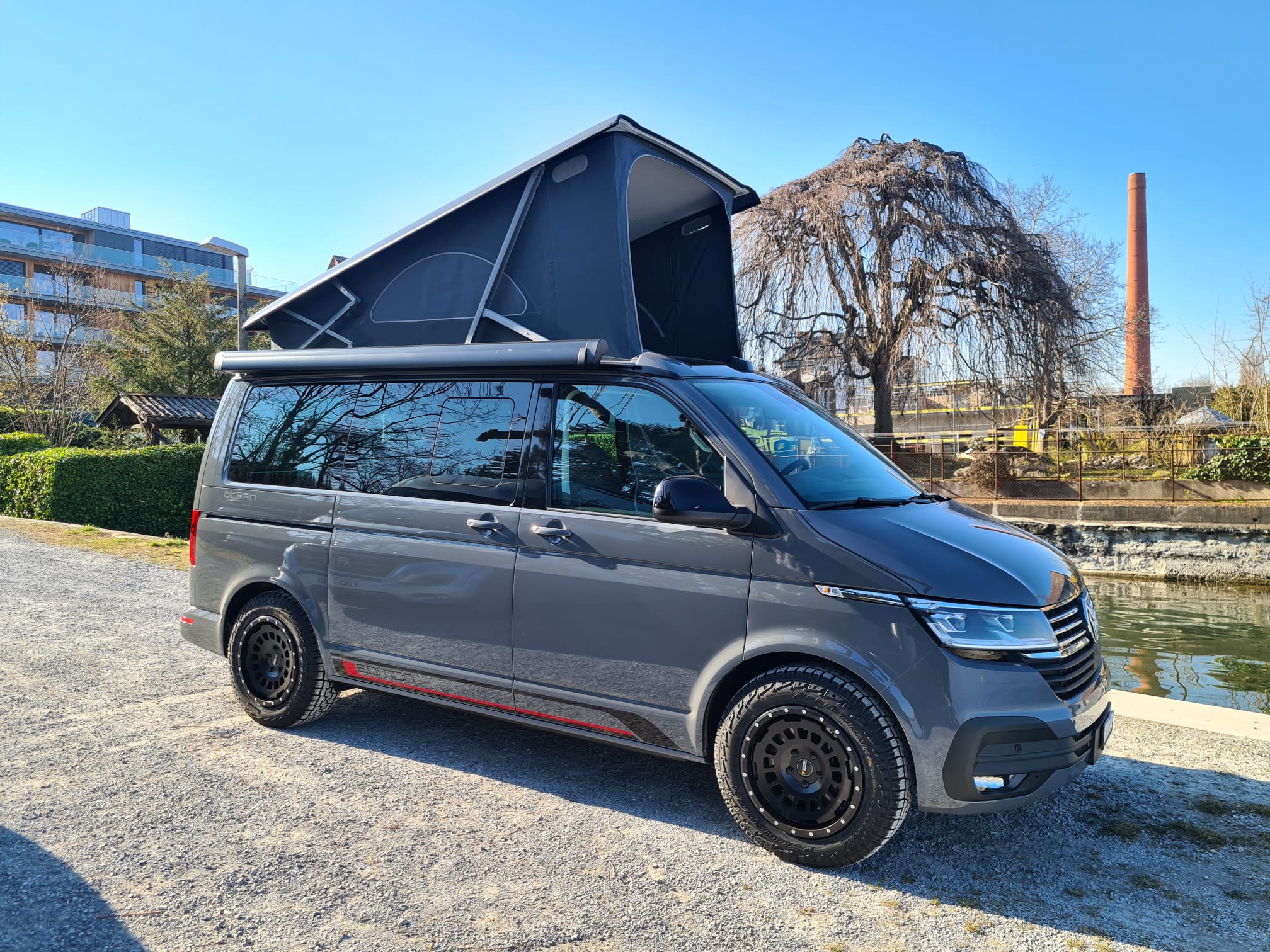 Jerry-VW-Camping-Bus-T6-mausgrau-schräg-von-vorne-offenes-hubdach